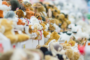 Variety of plush animal toys in boxes on shelves in supermarket.