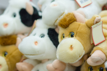 Plush cows toys on shelves in supermarket