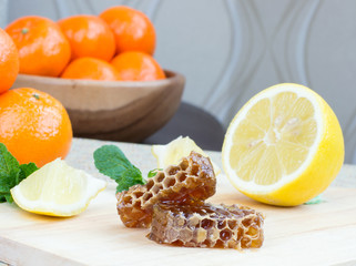 Fototapeta na wymiar Honeycomb, lemon and mandarins
