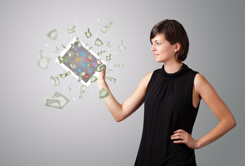 young woman holding tablet with money