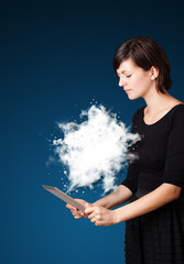 Young woman looking at modern tablet with abstract cloud