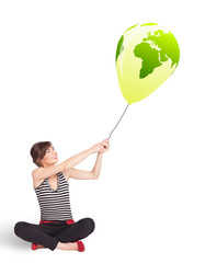 Happy lady holding a green globe balloon