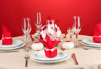 Table setting in red tones on color  background