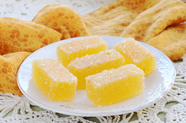 Homemade tangerine jellies on crocheted tablecloth