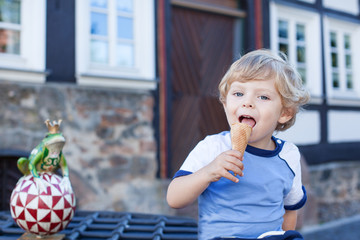 Little toddler boy eating ice cream in cone