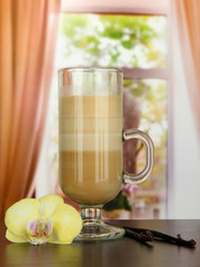 Fragrant coffee latte in glass cup with vanilla pods,