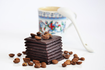 Chocolate with coffee beans and unfocused cup of coffee