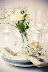 table setting with roses in bright colors and vintage crockery