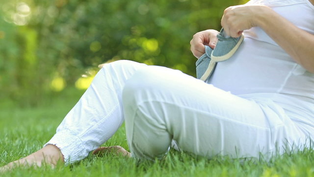 Closeup hands of pregnant woman holding bootee