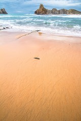 Cerrias beach with the sea and cliffs in the background