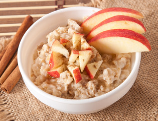Oatmeal with apples and cinnamon in a white bowl 