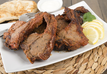 Grilled Tikka Lamb Chops with naan, lemon wedges and raita