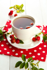 cup of tea with hip roses, on wooden table