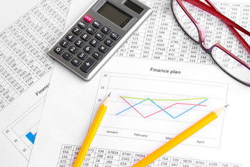 Documents, calculator and glasses close-up.