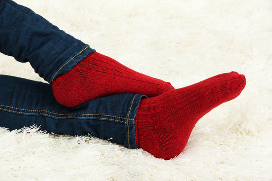 Female legs in colorful socks on  white carpet background