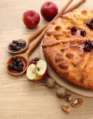 tasty homemade pie with jam and apples, on wooden table