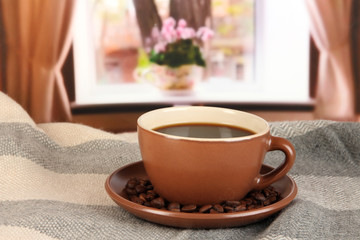 cup of coffee with scarf on table in room