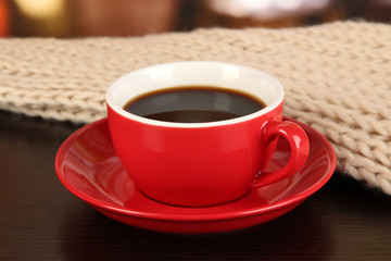 cup of coffee with scarf on table in room