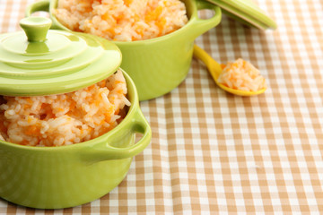 Taste rice porridge with pumpkin in saucepans