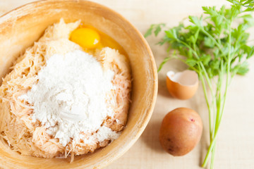 grated raw potatoes, eggs and flour in a large bowl