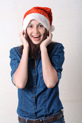 surprised girl in jeans and rad santa hat