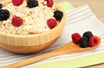 tasty oatmeal with berries, on wooden table