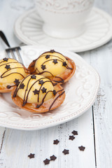 Sweet cakes with cup of tea on white table