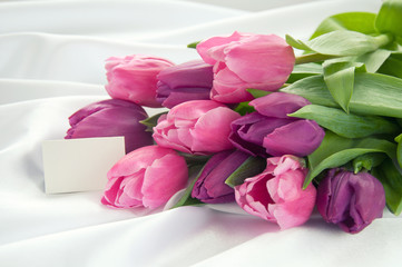 Pink and violet tulips on white silk with card
