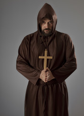 Monk in brown robe praying