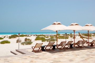 Sunbeds and umbrellas at the beach of luxury hotel, Abu Dhabi, U - 48795768