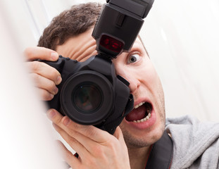Fototapeta premium Portrait of fun expressive male photographer with camera