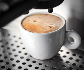 White ceramic cup of fresh espresso with nice foam in the coffee