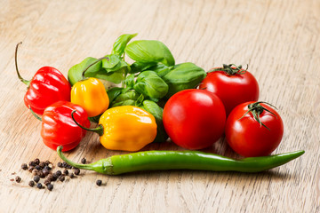 Mix of peppers and tomato on wooden table