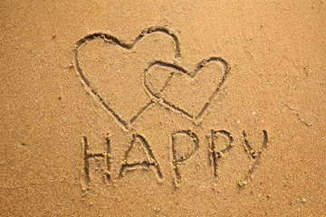 Texture of sand: the inscription happy and two hearts