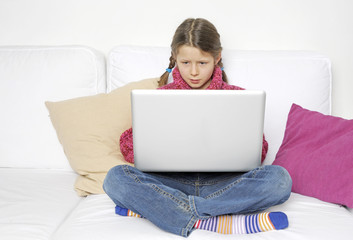 Kind arbeitet konzentriert an Laptop