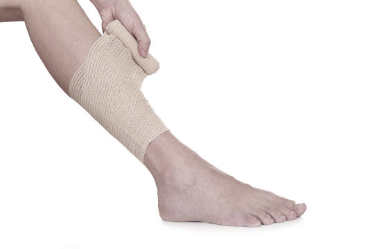 Bandaging Leg With Elastic Bandage On White Background.