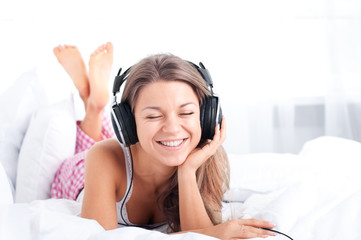Naklejka premium Listening music on bed