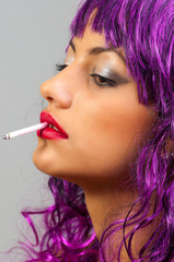 Obraz premium Profile of the beautiful girl with cheap purple wig smoking