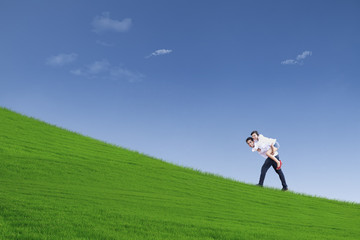 Guy giving piggyback ride under blue sky