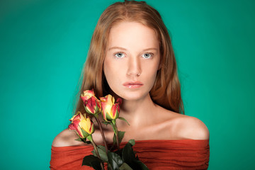 Fashion beauty portrait of woman with flowers and red hair.