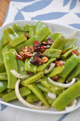 Zuckerschoten Salat mit Zwiebel und gerösteten Haselnüssen