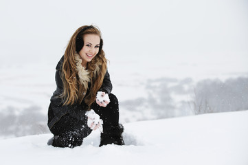 Piękna dziewczyna bawi się na śnieżnym zboczu góry - obrazy, fototapety, plakaty