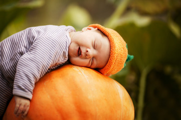 baby sleeping on big pumpkin