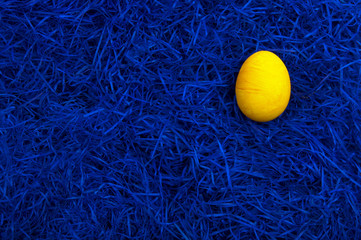 Yellow easter egg on dark blue background