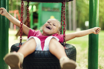 Obraz premium Happy girl having fun on playground