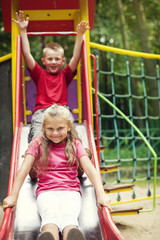 Two kids having fun on slide