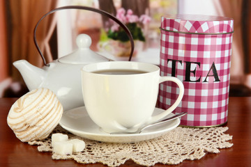 Jar and cup of tea on table in room