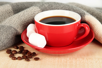 cup of coffee with scarf on table in room
