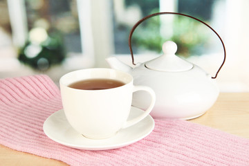 cup of tea with scarf on table in room