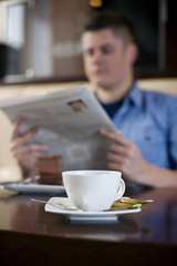 Reading newspaper in cafe